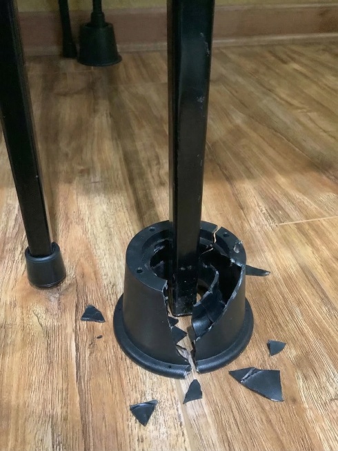 修改原图片，黑色金属桌腿将黑色的锥形底座中心位置彻底烂空了，呈现出中心塌陷破损的效果预览效果
