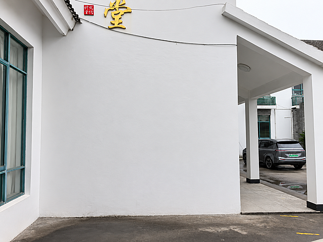 去掉墙面的广告牌和小告示牌，修补墙面，保持与原有白墙风格、颜色一致，保留墙面上方的金色大字和红色标牌，整体和原图风格统一