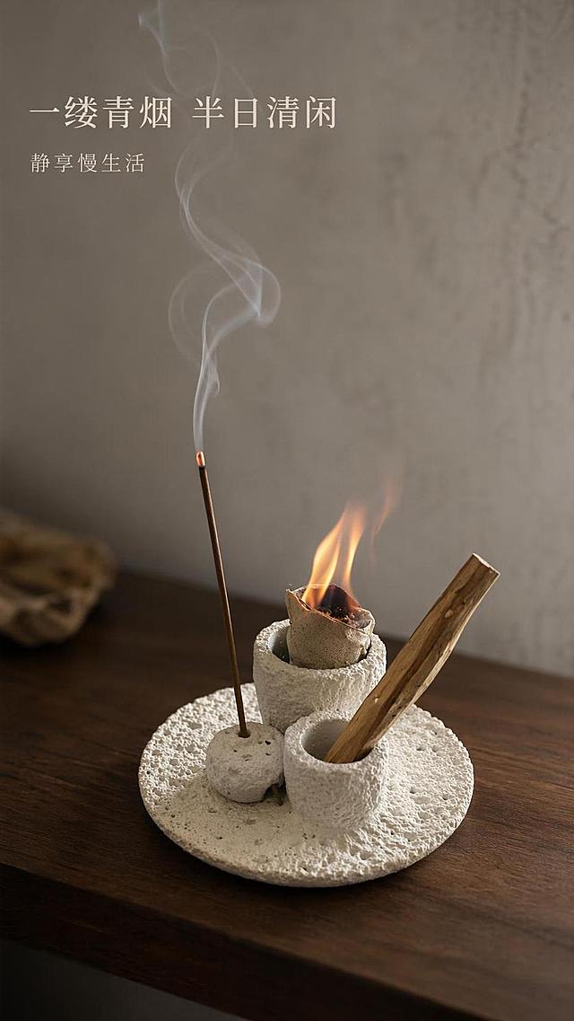 [第4屏] 使用瞬间-寂诧风水泥香插点燃熏香动态展示。本屏使用【图1】作为商品主体。
[氛围/风格] 静谧治愈氛围，动态轻烟朦胧感，温暖松弛的感官体验。
[元素布局] 保留香插原有产品结构，香正在燃烧，轻烟从香头慢慢升起，营造禅意氛围感；香插放置在深棕色木质台面上，背景为浅灰色微水泥墙面；产品主体结构和颜色与原图一致。
[光影质感] 暖调柔光，突出火焰和轻烟轮廓，背景柔和虚化，焦点集中在香插和轻烟上。
[配色色系] 全局底色 #D8D6D3，主色水泥灰白，辅助色火焰橘黄、轻烟浅灰、深棕台面。
[视角构图] 平视斜侧角度，浅景深突出产品主体和燃烧状态。
[文字版式] 左上角标题，右下角留白。主标题「一缕青烟 半日清闲」，副标题「静享慢生活」，字体素雅清淡，不遮挡主体。
[比例分辨率] 9:16 竖版比例，4K分辨率，文字清晰可辨，高清画质。
[负向提示词] 产品变形，缺件错件，颜色偏差，火焰模糊，文字错乱。