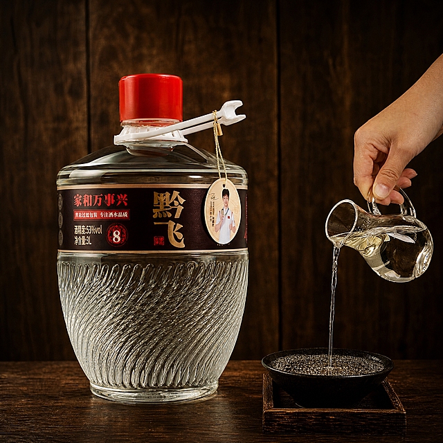 参考第一张图的整体风格和场景布局，深棕色木质背景，复古中式白酒场景，暖光氛围，画面中央放置第二张图中的黔飞牌3L装透明玻璃大桶白酒（红盖、带白色提手、瓶身有斜纹纹理、深色标签写有黔飞家和万事兴字样、挂有圆形吊牌），右侧保留一只手拿着玻璃分酒器正在往黑色碗中倒酒的动作，去掉画面左侧的高粱和散落的高粱粒，去掉右侧的白色酒具（白色酒壶和白色小酒杯），桌面为深色木质台面，整体氛围古朴典雅，白酒产品摄影风格，高清质感，1:1正方形构图