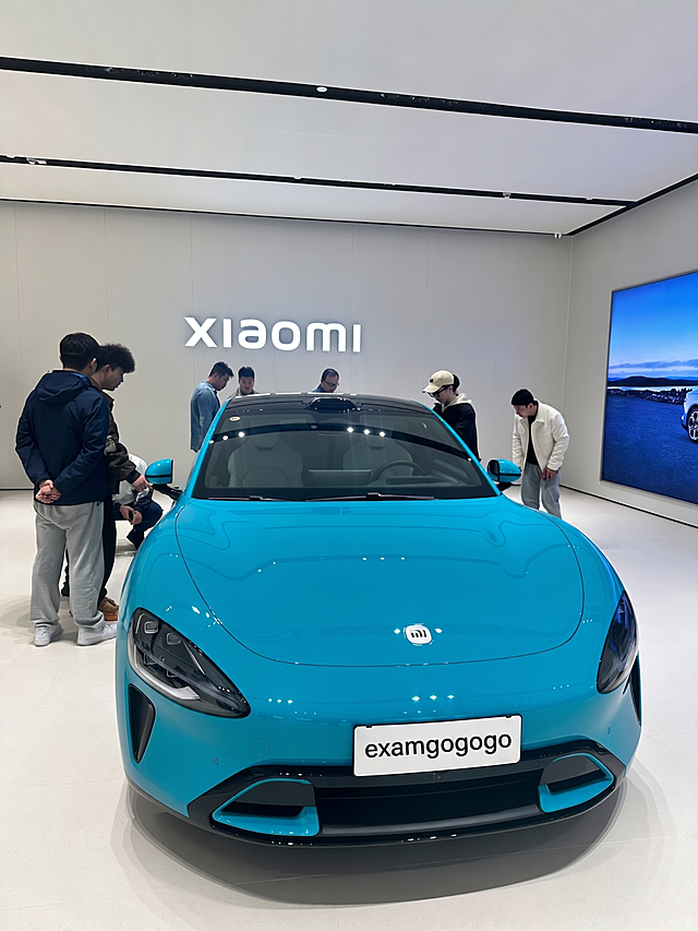 将图片中车牌上的文字Xiaomi su7修改为examgogogo，保持图片整体不变，只修改车牌文字，保持原有背景和风格一致