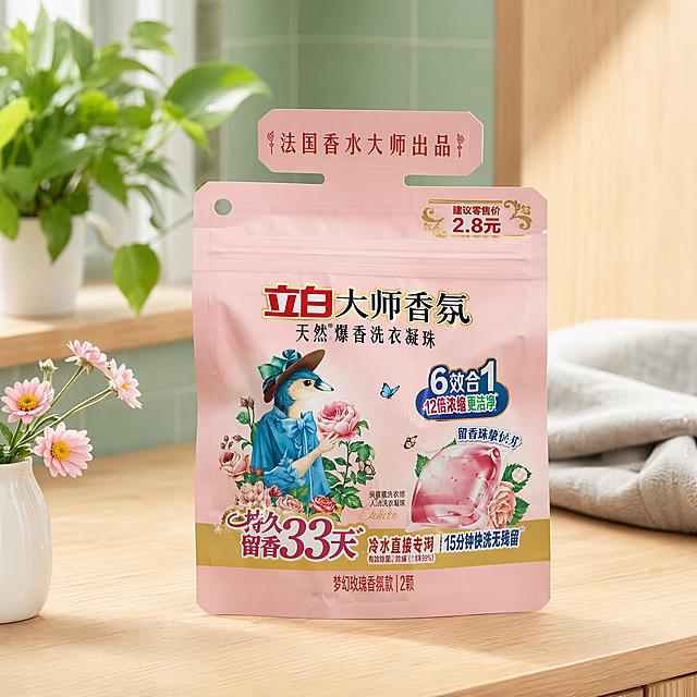 超写实电商产品摄影，北欧清新风
主体：立白大师香氛洗衣凝珠包装严格参照上传产品图，完整保留所有可见文字、logo、轮廓、结构、比例、颜色，产品本体完全一致。占画面65%，完整不裁切，近景景别，包装为第一视觉焦点。
构图与陈列：正面平视，平稳放置于阳台原木洗衣柜台面，产品与场景同一物理空间，自然融入光影，无剪切抠图感。
风格：北欧清新温馨风
场景概念：洗衣凝珠放置在阳台原木洗衣柜，阳光午后日常清洁场景，明亮清新生活化氛围
承载与背景：①台面：浅原木色实木洗衣柜台面；②背景：浅薄荷绿色墙面瓷砖，柔焦虚化处理。
陪衬物：①画面后方，原木色洗衣柜柜门一部分，浅原木木纹；②台面左前方，一小束浅粉色洋甘菊花束，浅粉色花瓣绿色花茎，插在白色陶瓷小花瓶；③台面右后方，一块灰色棉麻洗衣布，浅灰色棉麻质感；④左后方，一盆绿色绿萝叶片，深绿色，点缀背景。
配色：主60%浅原木薄荷绿，辅25%米白浅灰，点缀15%浅粉色，主色浅原木、薄荷绿，辅色米白、浅灰，点缀浅粉色
光影：主光从后方阳台窗户自然光斜入，照亮包装正面，整体画面柔光漫射，明亮清新暖调，无硬阴影。
参数：4K写实光学追踪。严格锁定宽高比为 1:1。