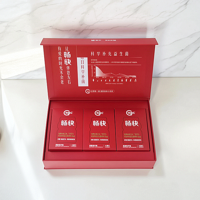 为优益C畅快益生菌产品生成高端精致的场景图，产品为红色包装，放置在明亮干净的桌面场景中，柔和自然光，简约高级风格，突出产品质感，画面干净清爽，商业摄影质感