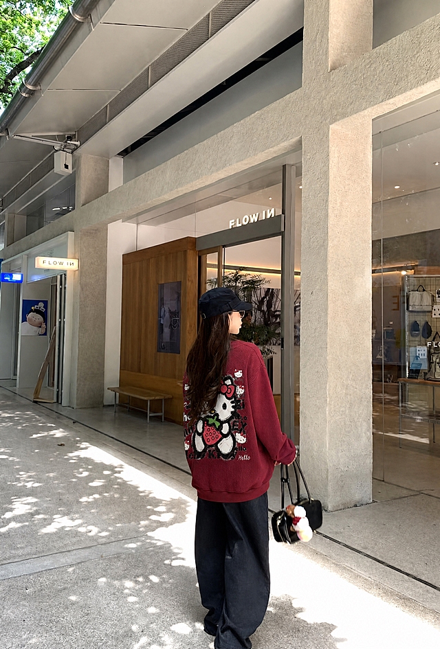 将图4和图5的酒红色华夫格Hello Kitty卫衣穿到图1模特身上，衣服版型、花色、纹理、面料严格复刻参考服装，正面左胸有白色手写体"Utopia Coming Soon"字样，背面有大的Hello Kitty抱草莓图案和多个小Kitty头像及文字涂鸦。真实人像摄影，自然光，皮肤质感真实，高清，写实，柔和环境光影，衣服贴合身体，服装褶皱自然，无水印，无文字，无logo，无畸形肢体，画面干净，不要改变人物长相，保持原图背景和人物姿势不变。