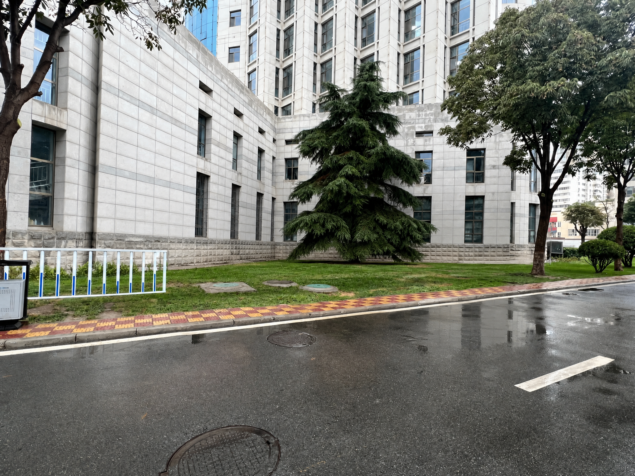 移除图片中街边的红色公告栏宣传栏，保留后方的灰色石材建筑、树木… - 图片创意预览