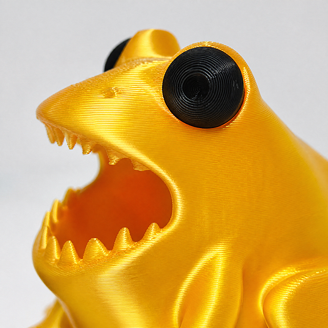 [Main Image 9] Golden frog pen holder detail close-up. Macro close-up of the golden frog pen holder's eye and body metallic silk texture, show premium 3D printing metallic finish, no burrs. [Atmosphere Style] High-end texture display, highlight golden version premium quality. [Quality] Macro photography, ultra clear detail, metallic luster natural and real. [Elements] Focus on the golden frog's eye and body surface texture, keep golden frog product 100% consistent with input golden product image, no color difference. Product detail occupies 80% of frame. [Light and Shadow] Side soft light, highlight metallic silk luster, clear light and shadow layering. [Color Matching] Pure white background, product golden luster prominent. [Perspective Composition] Macro close-up perspective, shallow depth of field, focus on detail. [Text Layout] No extra marketing text, comply with cross-border platform rules. [Proportion Resolution] 1:1 ratio, 2K resolution. [Negative prompt] Deformation, watermark, messy text, blurred product, messy background, Chinese characters