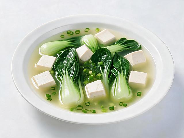 保留豆腐，将白菜替换为小青菜，制作家常青菜豆腐汤，保持白色盘子和纯白色背景，美食实拍风格，汤色清亮，豆腐块搭配翠绿小青菜，撒上葱花