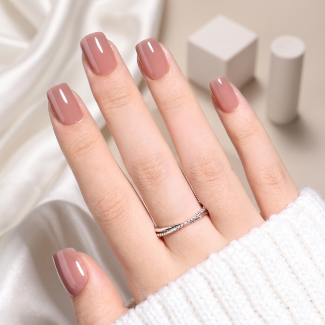 保留原手部和冰茶色穿戴甲，更换背景为极简美学背景，柔软白色缎面布料带有自然褶皱，背景中放置虚化的几何白色道具，整体暖中性色调，柔和漫射自然光，手部下方有细腻阴影，构图干净通透，高端美妆摄影风格，超清8预览效果