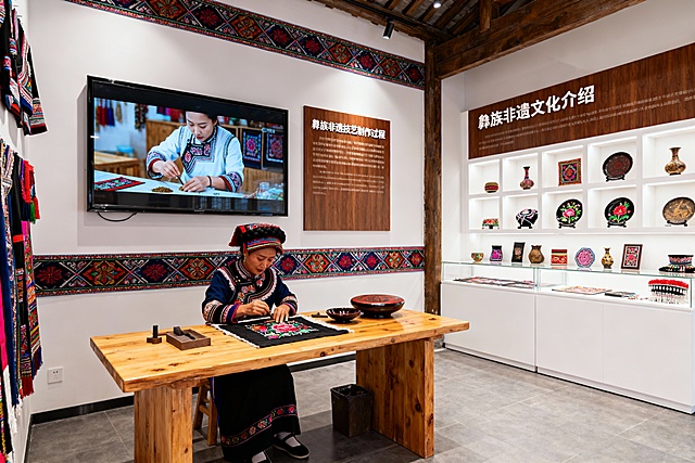 生成游客接待中心非遗技艺现场展示区，要有彝族元素，视频展示区域，文字展示区域，操作区，作品陈列去