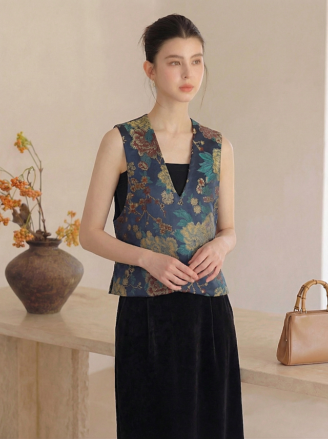 保持人物主体不变，保持深蓝色底彩色花卉提花马甲和黑色丝绒半身裙服饰不变，更换为不同的站立姿势，保留原来的室内场景和暖调光影风格，真实自然