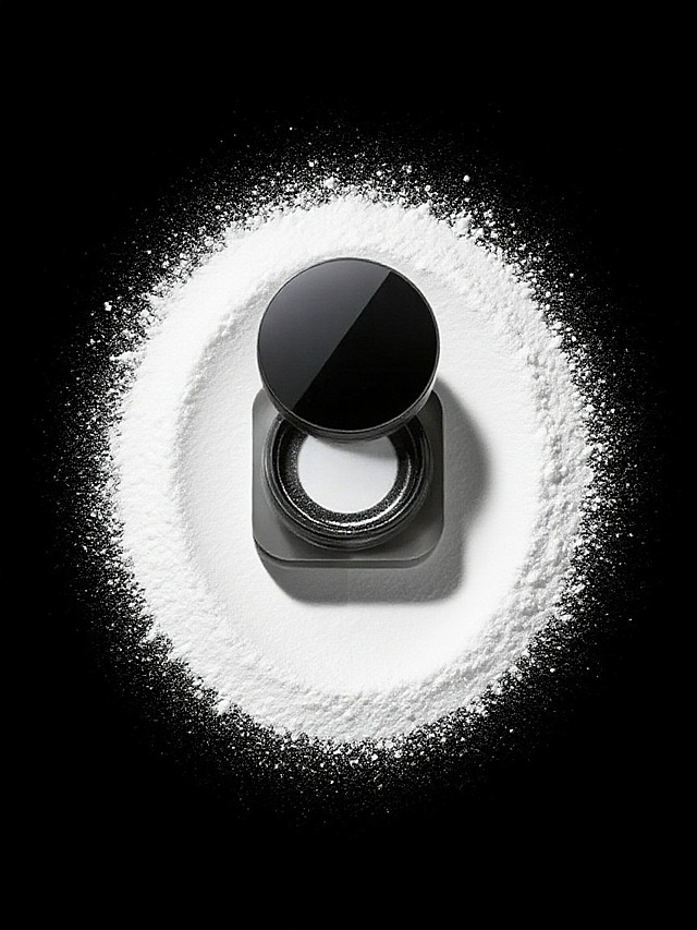 产品居中，周围是白色粉末呈圆形散开的效果，黑色背景