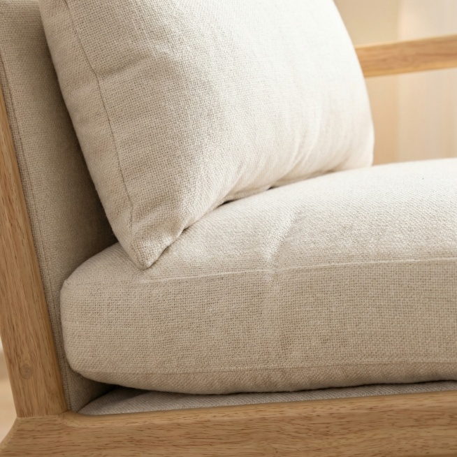 特写原木浅木框架米白色布艺休闲单人椅，重点特写展示座包靠背的布艺面料纹理和饱满填充，保留原产品形状、颜色和材质纹理，保持物理结构绝对不变，严禁扭曲形变。画面聚焦在坐垫和靠背面料区域，背景虚化浅景深，柔预览效果