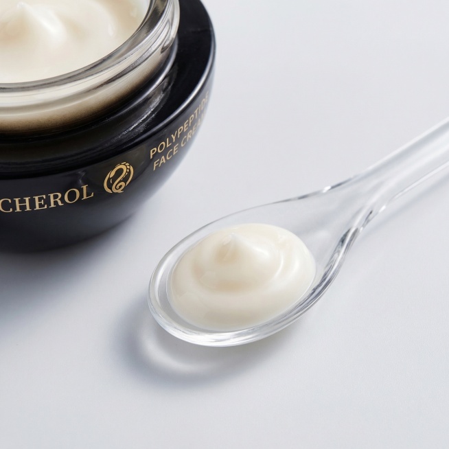 面霜质地细节特写图，挖取少量米白色乳霜质地的面霜放置在干净的透明玻璃勺上，特写展示面霜细腻柔润、有光泽的质地，背景为浅灰色极简背景，光线柔和凸显质地的丝滑感，旁边露出部分面霜罐体边缘，整体干净高级，比预览效果