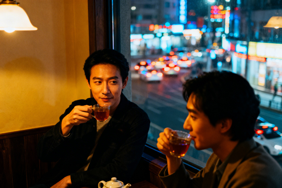 茶余饭后的两个人坐在窗户边上喝着茶在闲聊。窗外的背景是车水马龙的夜景预览效果