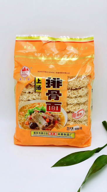 [主图主题] 美之泉上汤排骨面产品主图
[氛围/风格] 干净简约食品电商风，突出面饼天然质感
[画面元素] 袋装美之泉上汤排骨面搭配叶片装饰展示在浅色干净背景上，保留原有包装品牌、图案和文字信息，不添预览效果