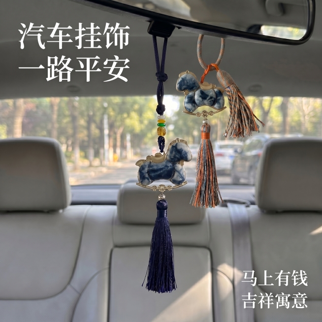 将图片1中右侧彩色流苏短款扎染小马挂件合成到车内后视镜位置，作为第二个汽车挂件展示，保持车内背景不变，挂件大小比例合适，光影自然和车内环境融合，保留原有文字 "汽车挂饰 一路平安" "马上有钱 吉祥寓预览效果
