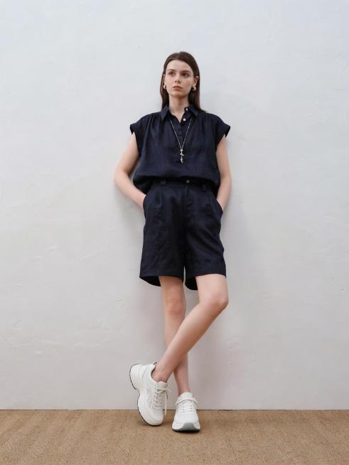 将图1模特脚上的鞋子替换为图2中展示的纯白色网面厚底运动鞋，保留原模特姿势、服装、背景和光影，不改变鞋子造型、颜色与LOGO，确保产品原始设计完整保留，鞋子细节清晰预览效果