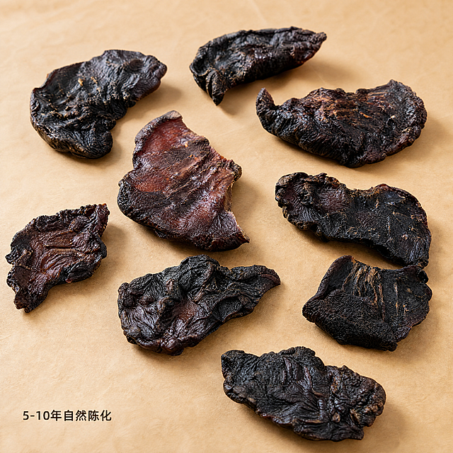 [主图-4] 肉苁蓉干货产品真实陈列展示。氛围风格：原生干货展示，自然真实感。画质：商业摄影质感、光线柔和通透、产品清晰真实、画面干净高级。元素：多块不同大小的肉苁蓉残片错落摆放在牛皮纸上，保留产品外观（物理结构、材质质感、颜色）与输入产品图绝对一致，杜绝任何变形和色差，精细化处理。错落分布，商品主体占比约60-70%，画面满屏无边框。背景浅牛皮纸原色，简单干净突出产品本身。光影：均匀散射自然暖光，让每一块产品都清晰呈现纹理，阴影柔和不杂乱。配色：深棕色产品和浅卡其色背景对比分明。视角构图：45度斜俯视整体陈列，全面展示产品形态。文字版式：左下角小字标注"5-10年自然陈化"，深棕色清晰可读，不抢主体。比例分辨率：1:1比例，4k分辨率，文字清晰锐利，画面超高清。负向提示词：变形，水印，文字错乱，产品图模糊，背景杂乱，夸大功效表述，医疗宣传内容。