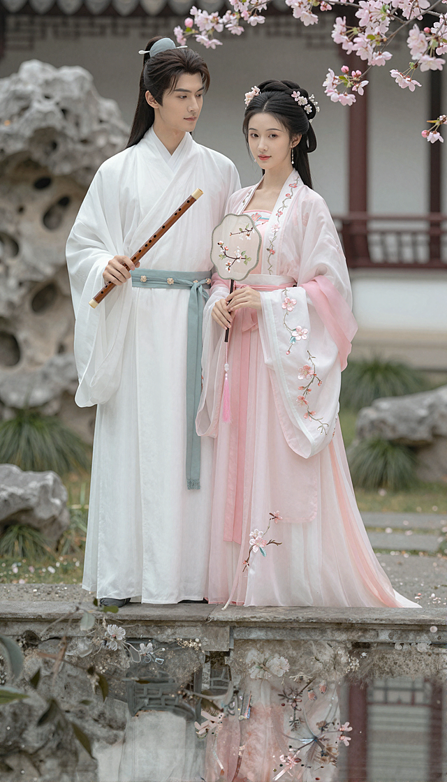 超精美的古风女频男女主形象，男子身着月白锦袍，腰束玉带，面容俊朗温润，手持玉箫；女子身穿粉白襦裙，裙摆绣满缠枝海棠，眉眼温婉秀丽，手持团扇，背景是古雅的庭院，有假山、海棠花树，整体画风细腻唯美，充满古风韵味