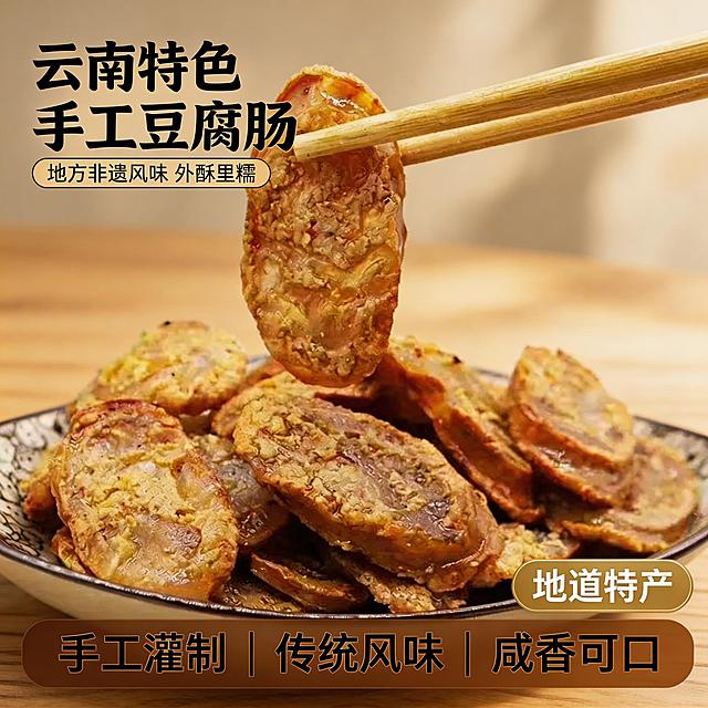 [垫图] https://gdesign-dam-hz.dancf.com/35849230916769941/c317647619354ce6a18ba0cde0d6a446.jpg
[主图主题] 云南特产豆腐肠首图主图
[氛围/风格] 高级暖调美食摄影，浓郁食欲感，油润焦香质感
[画面元素] 切好的云南豆腐肠在花纹瓷盘里居中展示，一块豆腐肠被筷子夹起悬空，油光光泽感明显；背景是干净的浅米原木餐桌，柔和暖光从侧方打来，形成自然光影，光斑洒在产品上，产品主体占比约60%，背景铺满全屏无边框
[配色色系] 主色调：暖棕橙（豆腐肠）；辅助色：米白浅木色（背景），暖黄调光影
[视角构图] 平视45度，景深适中，产品主体突出
[文字版式] 主标题 “云南特色 手工豆腐肠”，副标题 “地方非遗风味 外酥里糯”，左上角悬浮排版；右下角金底白字标签 “地道特产”；底部三列卖点 “手工灌制 | 传统风味 | 咸香可口”，字体为粗黑无衬线体，深棕色文字，底部做半透明渐变蒙层框。整体采用左文右图经典布局，文字留白合理不遮挡产品，信息层次清晰。