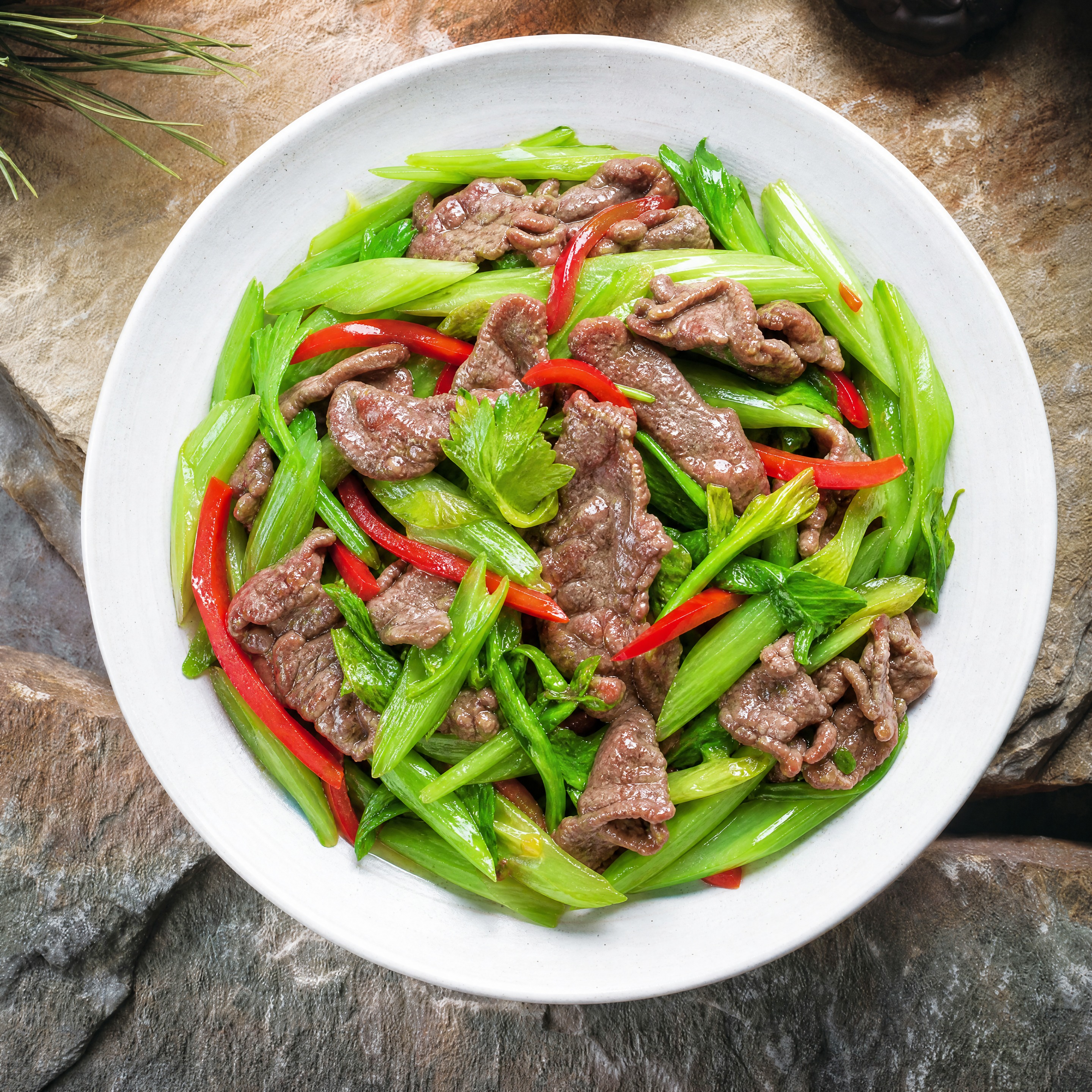 俯视角度，白色圆形瓷盘中盛放着西芹清炒牛肉，西芹翠绿爽脆，牛肉… - 图片创意预览