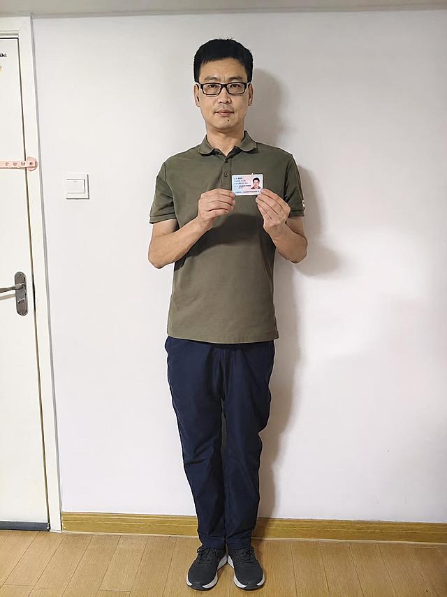将人物脚上的蓝色拖鞋替换为深色休闲运动鞋，款式简约百搭，与整体穿搭风格协调，保持人物姿态、裤子和背景完全不变，鞋子光影和透视角度与原图一致，真实自然