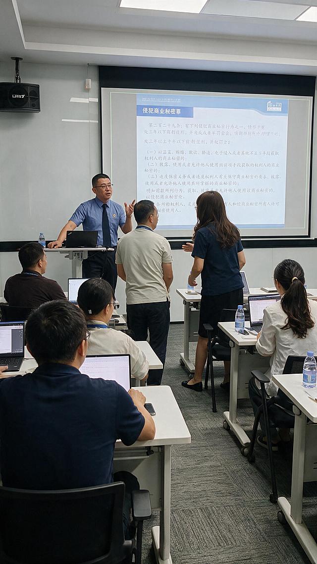 参考这三张活动照片的内容与风格，生成一张 9:16 竖版的高质量活动照片：现代会议室/培训教室中，一位穿浅蓝色衬衫、系深色领带的讲师正在授课并讲解，背景投影屏幕显示法律培训内容（“侵犯商业秘密罪”及德恒律师事务所标识），台下听众坐在白色长桌前使用笔记本电脑，讲师与学员之间有互动交流；画面写实自然、光线明亮均匀，人物和场景氛围与参考图保持一致，构图适合竖屏传播。