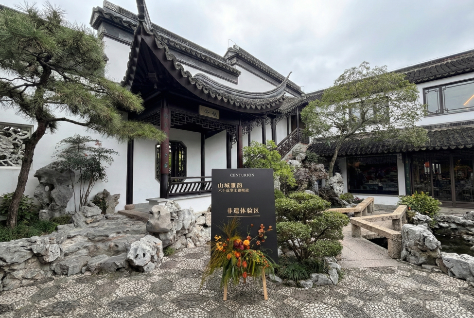 图1右侧迎宾牌放置到图2画面的下部，假山石的前面。预览效果