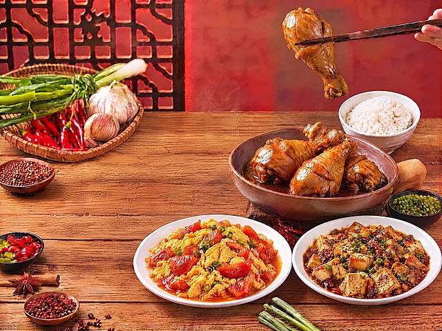 同时移除画面中的回锅肉（左下方白盘）和辣椒炒肉（上方白盘）两道菜及其盘子，其余所有菜品、卤鸡腿、米饭、背景装饰、餐具、光影、构图完全保持不变，移除后露出的木桌面纹理与周围自然衔接，真实自然无违和感