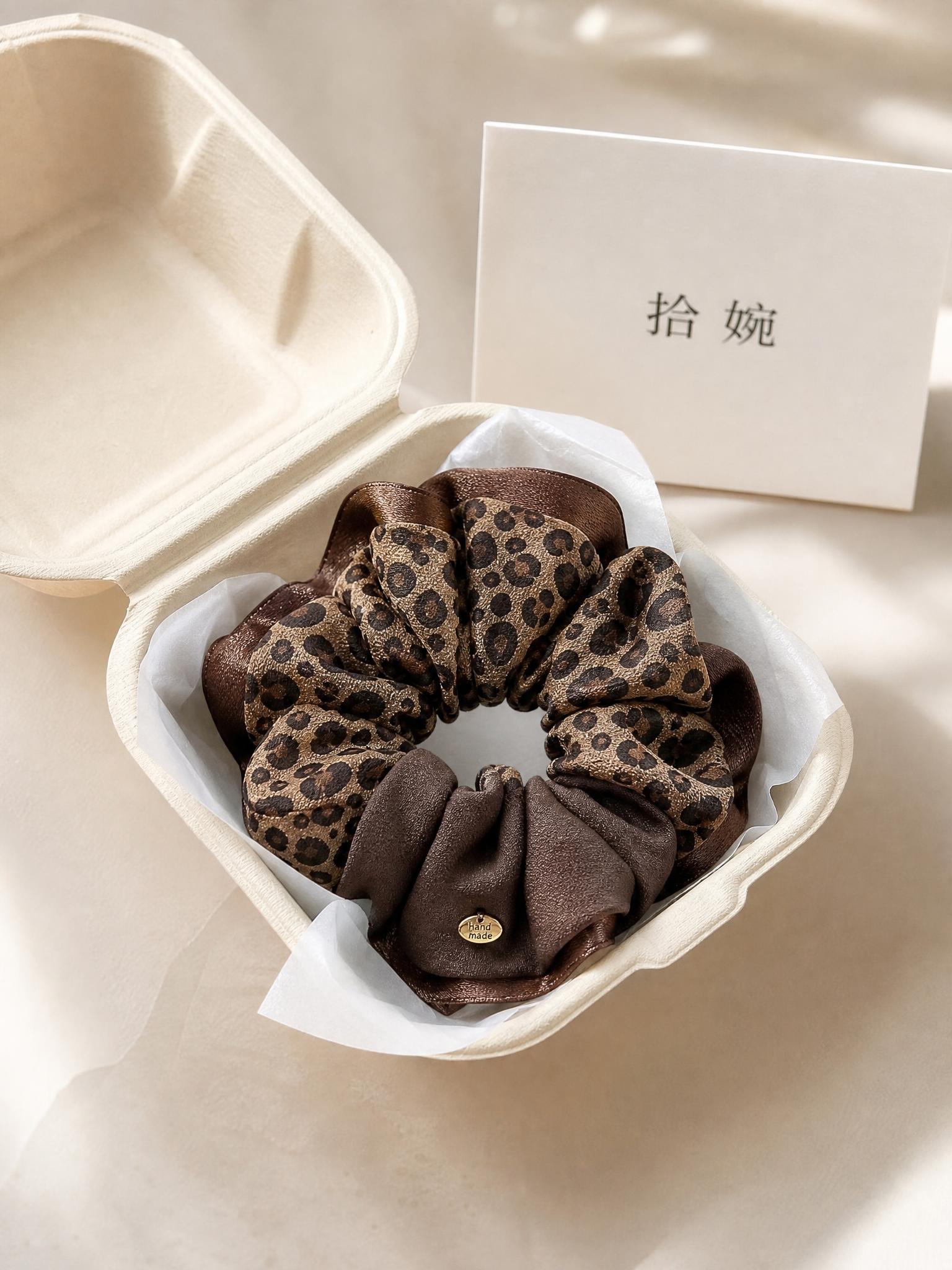俯拍平铺静物摄影，高级感豹纹大肠发圈（豹纹与深棕色拼接，带金色… - 图片创意预览