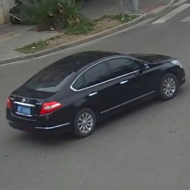 原图是左前侧视角的黑色日产轿车，道路监控俯视角度，生成此车右后侧视角的外观照片，保持车型、品牌、颜色、白天、天气、环境一致，1:1尺寸预览效果