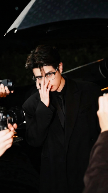 将图1中人物佩戴的眼镜替换为参考图2的黑银拼接眉框眼镜，贴合人物扶眼镜的手部姿态，适配自然，其余画面特征保持不变预览效果