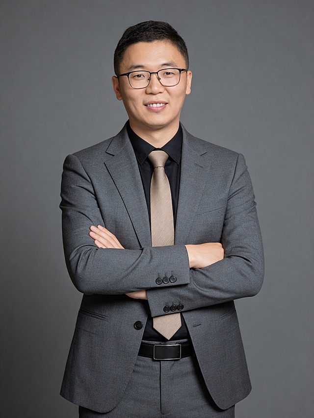 参考第一张图保留人物脸型､年龄等特征生成职场形象照,参考第二张图人物占位和比例,标准焦段50mm,F/4光圈(F/2.8-F/4区间),平视视角(镜头与人物视线齐平);人物占画面70%,人物居中(居中构图),位于画面中心,为视觉聚焦点,入境范围头部及以下至臀部区域(半身像);左右留少量背景空间;头部与画面顶部保留5%空间;头部发型完整;头肩比例协调,身穿修身精纺羊毛混纺面料的灰色西装外套,平驳领(商务感正式感),西装下摆自然垂度;内搭深色翻领衬衣,搭配高级浅咖色领带(含5%桑蚕丝提升柔光质感),下装精纺羊毛混纺面料的灰色西裤(面料同西装),搭配暗色哑光皮带(宽1.5cm),带扣为长方形拉丝黑色金属(1.8cm×2.5cm);呈正面抱胸的自然站立姿态:左臂搭于右臂上方,肩颈自然松弛下沉,姿态自信从容｡正式严谨专业稳重,身形匀称,姿态端正｡发梢微微修整干练大气,主体锐利,影棚侧光布光(主光来自画面前方),明暗过渡柔和,背景光线均匀,强化色彩对比的高级感｡哑光简约中深灰色纯色背景(呈现均匀柔和质感),极简干净;32K画质超高分辨率､细节清晰,整体风格雅致､兼具现代精致感;肤质精细化处理;眼神直视镜头,目光坚定且澄澈,表情自然.嘴角上扬;肌肤白皙透亮,柔光提亮,细腻无瑕,通透高级,干净清透肤质,肤色均匀,柔光美白细腻陶瓷肌肤,自然提亮,光影柔和通透水光肌,肤质细腻平滑干净哑光肤质,无油光无暗沉,肤色均匀提亮;杰作,最佳画质,超高细节,写实摄影,中近景人像,面部清晰,五官精致,皮肤细腻通透,白皙清透皮肤,干净肤色,健康肤色,无蜡黄,无暗沉,无黄皮,柔光,正面补光,面部光线均匀明亮,无浓重阴影,冷色调白平衡,画面干净清新,色调明亮,对焦清晰,肤质细腻,高清皮肤细节;面部光比1:1.5,4800K中性光,微微修饰脸型,肤质哑光细腻,面部微微雾面柔光,轻透裸肌感,真实毛孔纹理,32K画质,去除人物之外的所有元素｡严格按照第一张图内容生成｡