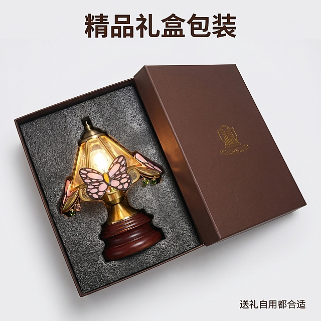 [主图-7] 黄铜实木蝴蝶台灯包装展示，强调礼盒品质
[氛围风格] 精致高端，送礼合适
[画质] 商业摄影质感、光线柔和通透、产品清晰真实、画面干净高级
[元素] 打开的礼盒包装，台灯平稳放置在定制珍珠棉内衬中，周围有防碰撞保护，展示完整包装细节。保持黄铜实木蝴蝶台灯外观（即物理结构、材质质感、颜色）与输入产品图绝对一致，杜绝任何变形和色差，精细化处理。商品主体占比严格控制在70%左右；画面满屏无边框。
[光影] 柔和均匀布光，突出包装精致感，不刺眼
[配色] 礼盒深棕色搭配金色logo，整体高级感，保持产品原有配色
[视角构图] 俯视开盖角度，完整展示包装内部
[文字版式] 上方大字“精品礼盒包装”深棕色粗体，右下角小字“送礼自用都合适”，文字不遮挡主体
[比例分辨率] 1:1 比例，2k分辨率；文字清晰锐利，画面超高清，图片小于1M
[负向提示词] 变形，水印，文字错乱，产品图模糊，背景杂乱，价格信息，绝对化违禁词，“祈福”“供灯”字样