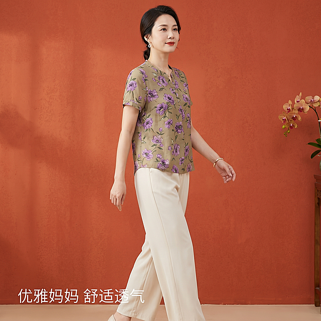 [主图 3] 母亲节妈妈装两件套完整穿搭展示图。氛围风格：高级感、松弛感、温馨母亲节氛围。画质：商业摄影质感、光线柔和通透、产品清晰真实、画面干净高级。元素：保持上衣和下装外观、材质质感、颜色与输入产品图绝对一致，杜绝任何变形和色差，精细化处理。同一位亚洲女模特，自然行走转身姿态，正面完整展示全身搭配，花卉印花上衣搭配米白色阔腿裤，整体比例协调，配饰和发型和前两张保持一致。商品主体占比严格控制在70%左右，画面满屏无边框，背景统一保留暖橘红色国风肌理墙，右侧保留蝴蝶兰花艺小装饰。光影：整体光线均匀柔和，突出套装整体版型，前后层次清晰。配色：主色调暖橘红，搭配卡其紫花米白，风格统一。视角构图：全身平视构图，从头到脚完整展示，不裁切关键部位。文字版式：左下角添加文案"优雅妈妈 舒适透气"，字体简约清晰，不遮挡主体。比例分辨率：1:1 比例，2k 分辨率，文字清晰锐利，画面超高清。负向提示词：变形，水印，文字错乱，产品图模糊，背景杂乱，换模特换脸，裁切身体，色差