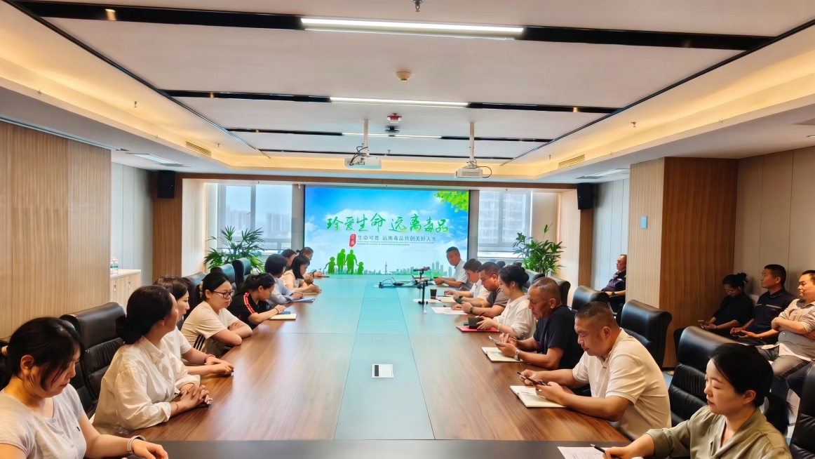 把图片中会议室大屏幕上的原有内容替换成第二张图片的禁毒宣传内容，其他位置和内容保持不变，不要做任何修改预览效果