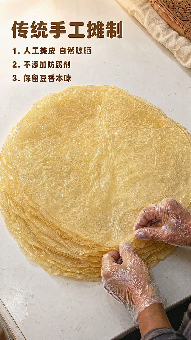 [第3屏] 传统手工摊制图修改：将原图中裸露的手替换为佩戴一次性透明手套的真实手部，保持动作、角度、光影与原图一致，确保自然真实。
本屏使用您提供的原图【https://33】作为基础。
[风格要求] 真实纪实摄影风，不夸张、不美化，仅替换手部为戴一次性手套的版本。
[元素布局] 画面主体仍为圆形豆油皮堆叠在白色台面上，右下角手部动作不变（轻揭/整理豆油皮边缘），仅将双手替换为佩戴透明一次性手套的真实手部，手套贴合手指轮廓，有自然褶皱和反光，不显塑料感。
[光影质感] 光线方向、强度、阴影位置与原图完全一致; 手套表面保留微弱高光，符合真实材质反射。
[文字版式] 左上标题「传统手工摊制」及三点说明（1.人工摊皮 自然晾晒 2.不添加防腐剂 3.保留豆香本味）位置、字体、字号、颜色全部保留不变。
[比例分辨率] 9:16竖版比例，4K分辨率，文字清晰，手部细节真实。
[负向提示词] 裸手未替换, 手套不真实（过厚/发白/无褶皱）, 改变豆油皮形态, 文字错位, 光影不一致, 过度修图。