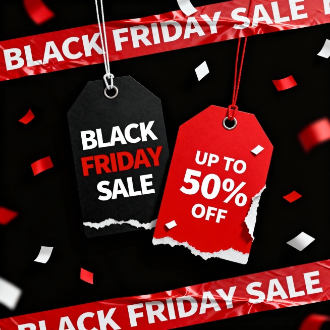 黑色星期五黑五黑色背景上，两个悬挂的促销标签——左侧黑色标签上用醒目白色和红色字体写着“BLACK FRIDAY SALE”，右侧红色标签上用白色字体标注“UP TO 50% OFF”，标签边缘有撕裂效果和白色小纸屑装饰。顶部和底部有贯穿画面的红色胶带，胶带上重复印有白色“BLACK FRIDAY SALE”字样，胶带略有褶皱和立体感。背景中散布着红色和白色的纸屑，营造出促销的热闹氛围。整体采用高对比度的红……预览效果