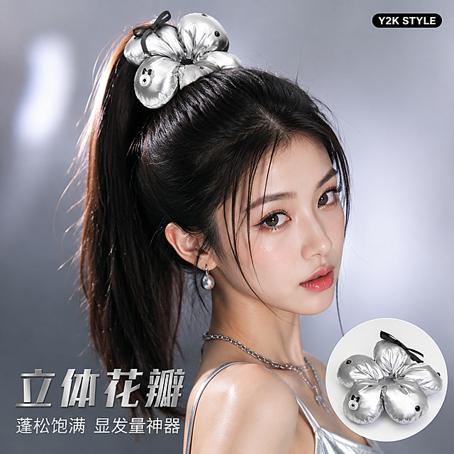 [主图-2] 花朵发圈佩戴效果展示 高马尾甜酷风。
[氛围风格] 甜酷Y2K风 时尚画报感 商业人像摄影。
[画质] 商业摄影质感 光线柔和 人物皮肤细腻 产品清晰真实。
[元素] 一位年轻亚洲女性模特 黑色长直发高马尾 佩戴银色充棉花瓣发圈 发圈饱满蓬松环绕马尾；模特妆容精致 甜酷风格 穿着银色吊带或黑色短上衣；背景为银灰色渐变墙面 带有微弱光斑；画面右下角小圆形插图展示发圈单品特写；保持发圈外观（充棉花瓣 银色亮面 小熊标 黑钻 缎带）与输入产品图一致 杜绝变形和色差；发圈在马尾上位置自然 真实接触点合理。
[光影] 前方柔光箱主光 均匀打亮面部和发圈 银色表面有自然高光；侧后方轮廓光勾勒发丝和发圈边缘；整体明亮通透 冷调高级感。
[配色] 主色银灰冷调；辅色黑色（缎带 发色 服装）；强调色肤色暖调点缀。
[视角构图] 正面偏45度 头部到肩部近景 发圈为视觉焦点 景深中等。
[文字版式] 左下负空间左对齐 主文案「立体花瓣」大号粗体银灰字 副标题「蓬松饱满 显发量神器」小号字；右上角小标签 Y2K STYLE 黑底白字圆角矩形。文字不遮挡脸部和发圈。
[输出要求] 1:1比例 文字清晰可辨 超高清商业摄影质感。
[负向提示词] 变形 文字错乱 产品图模糊 背景杂乱 水印 电商平台Logo 多余手指 手部扭曲 面部畸形。