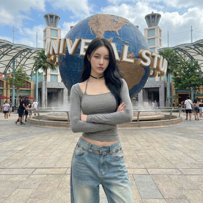 将背景替换为环球影城标志性大球场景，保持模特和服饰不变，更换为双手抱胸的姿势预览效果