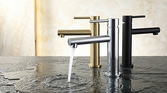 微仰视角度展示三款水龙头，最前方为铬色水龙头且正处于出水状态，后方按左到右依次摆放金色、黑色水龙头，摆放布局参考参考图，整体背景明亮不暗沉，大气高级，画面底部是纹理感较强的石板，石板表面有一层薄水。