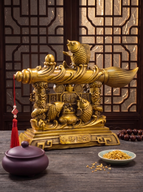 商业级产品摄影。
主体：黄铜风水摆件严格参照上传产品图，完整保留所有可见组件、部件、本体几何轮廓、结构、比例、材质质感、颜色、图案与上传图完全一致，严禁因画面氛围词擅改产品材质; 产品位于画面黄金主导预览效果