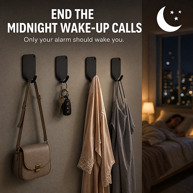 Amazon e-commerce main image, 1:1 square, matte black oval self-adhesive hook product. Scene: dim warm night bedroom. Four matte black oval self-adhesive hooks mounted on light grey wall, hanging crossbody bag, key set, silk robe and nightwear. Background softly blurred: bed with sleeping person, bedside lamp, night city view outside window. Top large white text: "END THE MIDNIGHT WAKE-UP CALLS", subtext: "Only your alarm should wake you." Moon and star decorative icon beside text. Cinematic warm low ambient light, cozy atmosphere, realistic product photography, high detail.