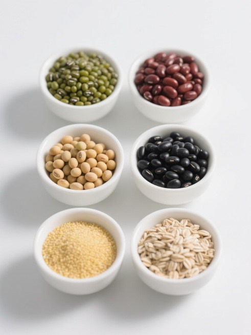 六个白色陶瓷碗规整排列在纯白色背景上，每个碗中分别盛放不同种类的杂粮谷物，包括绿豆（饱满圆润、鲜绿色带自然光泽）、红豆、黑豆、黄豆、小米、燕麦等，整体造型简约现代，高清晰度，光线柔和均匀，无阴影，无文字，无logo，无水印，保持真实摄影质感和简洁的视觉风格。预览效果
