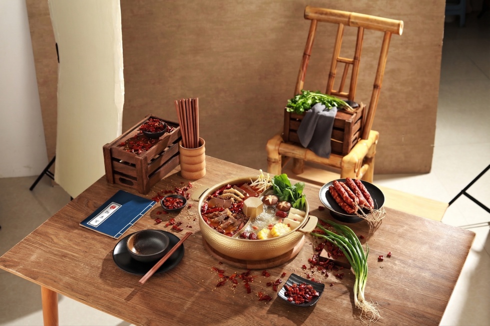 在鸳鸯火锅中添加火锅食材，保留原有的桌子、餐具、布置和整体构图风格不变预览效果