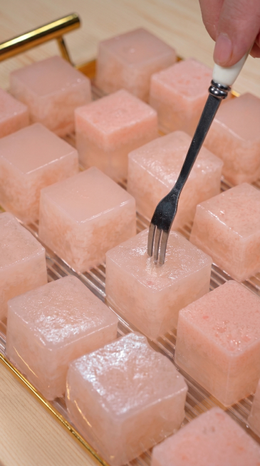 将背景案板替换为浅色纯木浆原木色，去除图片上下的手机UI边框以及图片中间的文字，保持图片主体内容（叉子插着粉色西红柿奶冻方块）不变，输出比例9:16预览效果