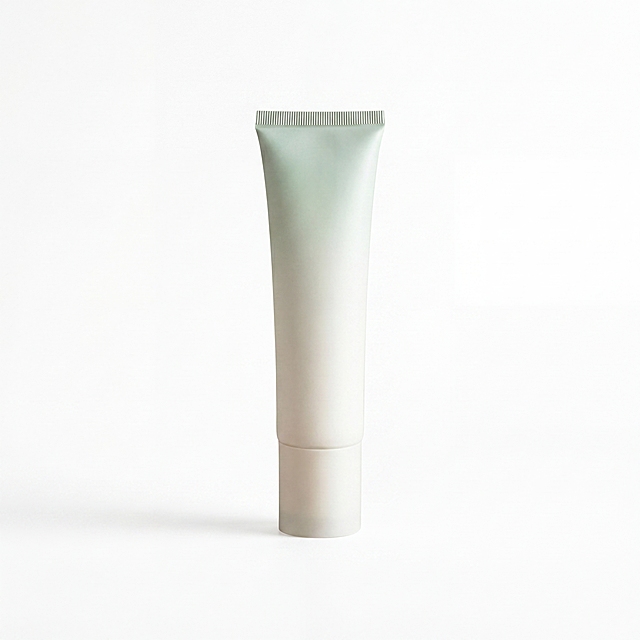 完美去底, 绝对 #FFFFFF 纯白背景, 仅允许商品接地处保留极轻接触阴影, 其余背景保持纯白纯净, 无噪点, 无马赛克, 无灰块
专业商业棚拍光, 5500K标准中性白光照明(严禁暖黄光导致偏色), 轮廓光, 体积光, 曝光绝对正确, 强烈的物理真实立体感, 居中构图, 商品主体占比严格控制在 60%-80% 之间
渐变浅绿色软管护肤品瓶身, 浅米白色瓶盖
极致超清画质, 电影级CG 3D渲染, 智能降噪, 深度细节锐化, 彻底消除模糊像素感, 8k分辨率, 修复一切划痕污渍指纹灰尘瑕疵，去除瓶身上所有文字文案
绝对锁定原图商品渐变浅绿到米白的颜色, 杜绝任何色差, 精准还原包装软管材质, 微距级材质纹理重构, 强制透视矫正, 自动水平校准, 摆正商品，保持正视图平视角度，增强瓶身光影立体感，提升整体质感和高级感，让商品看起来崭新精致，符合摄影棚电商主图标准