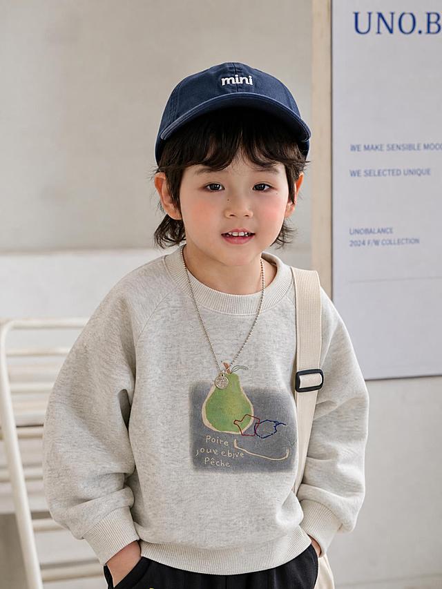 把浅灰色卫衣穿在这个小孩身上，模特身高90cm，比例匹配，场景是韩系时尚基地，半身照，更换和衣服搭配的帽子，根据衣服样式搭配配饰，3:4比例