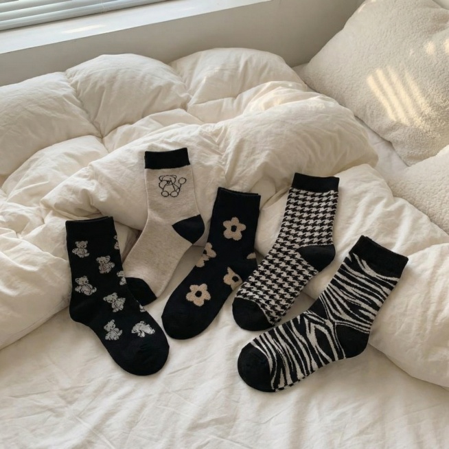 把图中的袜子换一个场景，场景在床上，随意的摆放，场景真实，生成3张图片预览效果