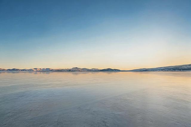 完全去除右侧的发光白色框架和剩余蓝橙渐变光影，保留当前光滑水泥地面、渐变天空和远山，将去除区域和原有背景自然融合，保持整体光影风格统一